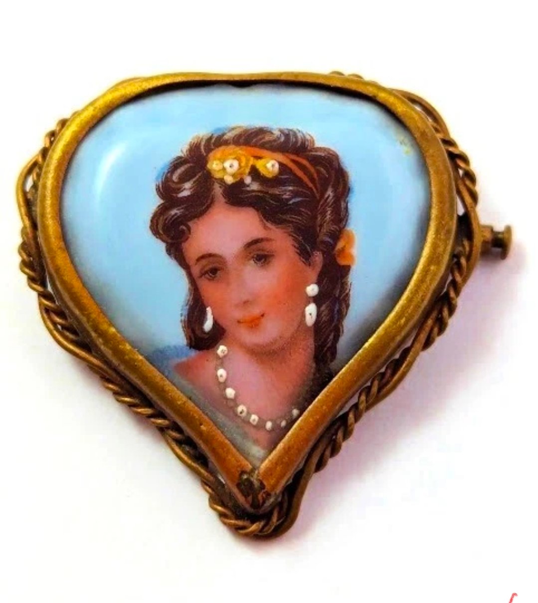 Heart-shaped porcelain brooch with a portrait of a young woman on a sky-blue ground, in a twisted brass frame
