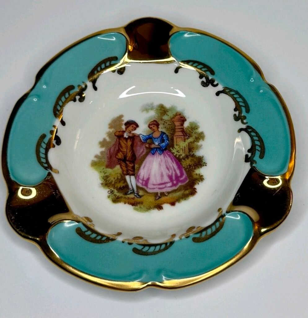 Round porcelain dish with a courting couple scene, turquoise panels and heavy gold