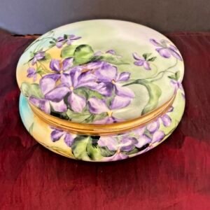 Large round porcelain dresser box hand-painted with purple violets on a pastel ground, with gold trim