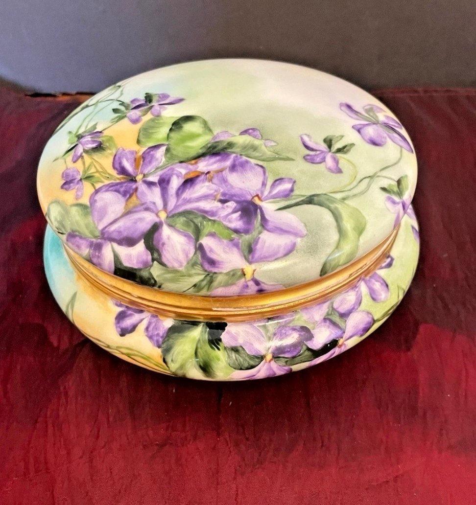 Large round porcelain dresser box hand-painted with purple violets on a pastel ground, with gold trim