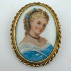 Oval porcelain portrait brooch of a fair-haired woman with blue flowers in her hair, in a rope-twist frame
