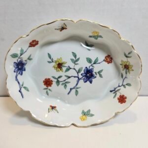 Scalloped oval porcelain dish with blue, red and yellow flowers on branches and butterflies, with a gold rim
