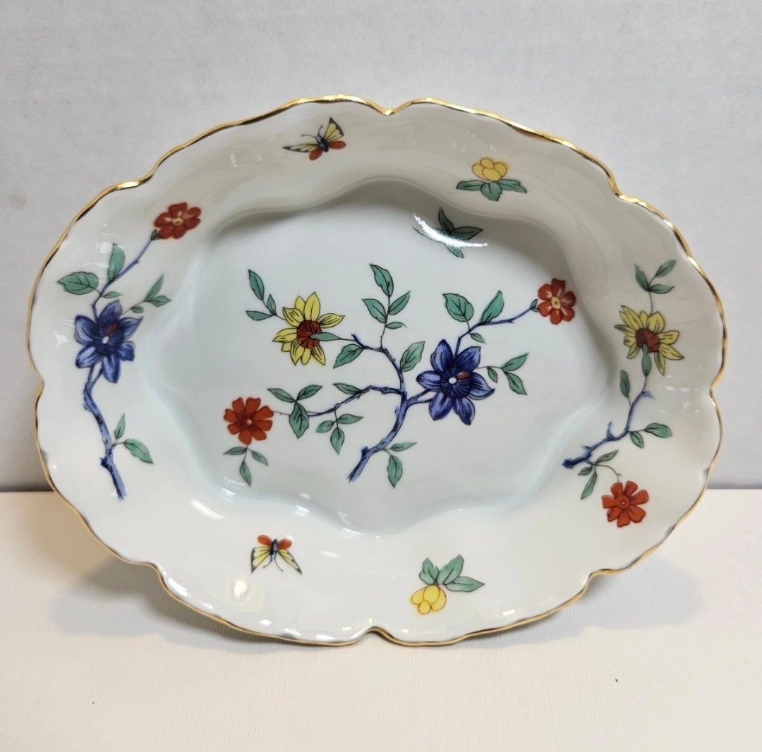 Scalloped oval porcelain dish with blue, red and yellow flowers on branches and butterflies, with a gold rim
