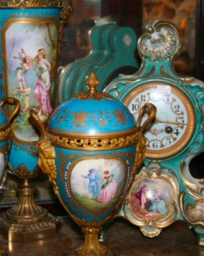 Antique French porcelain covered urn in celeste blue with gilt-bronze mounts and a hand-painted courting scene, beside a matching painted vase and a turquoise porcelain mantel clock